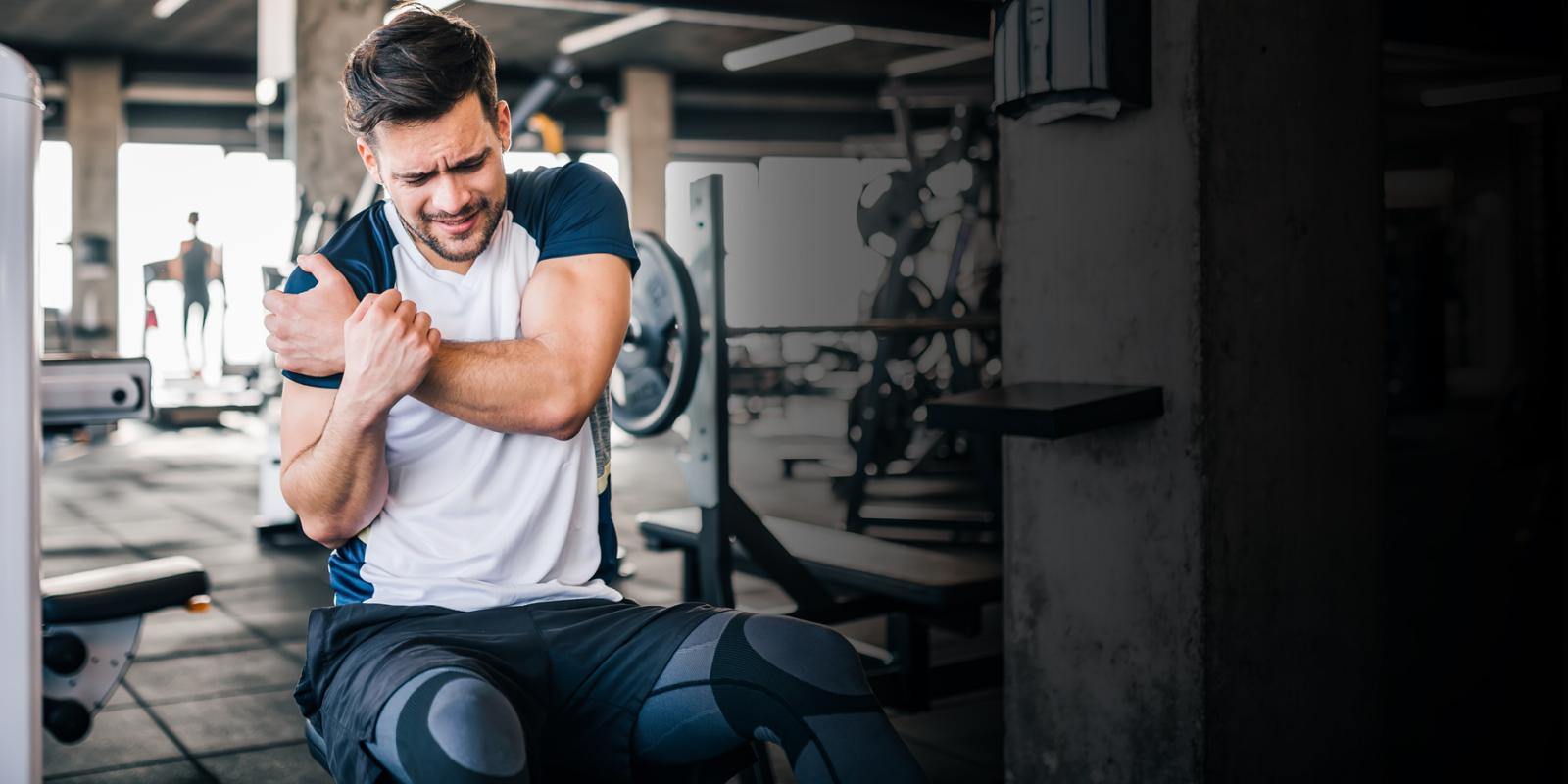 man holding shoulder in gym