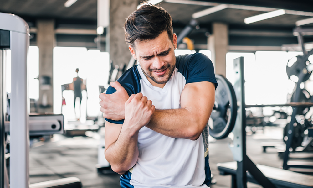 man holding shoulder in gym